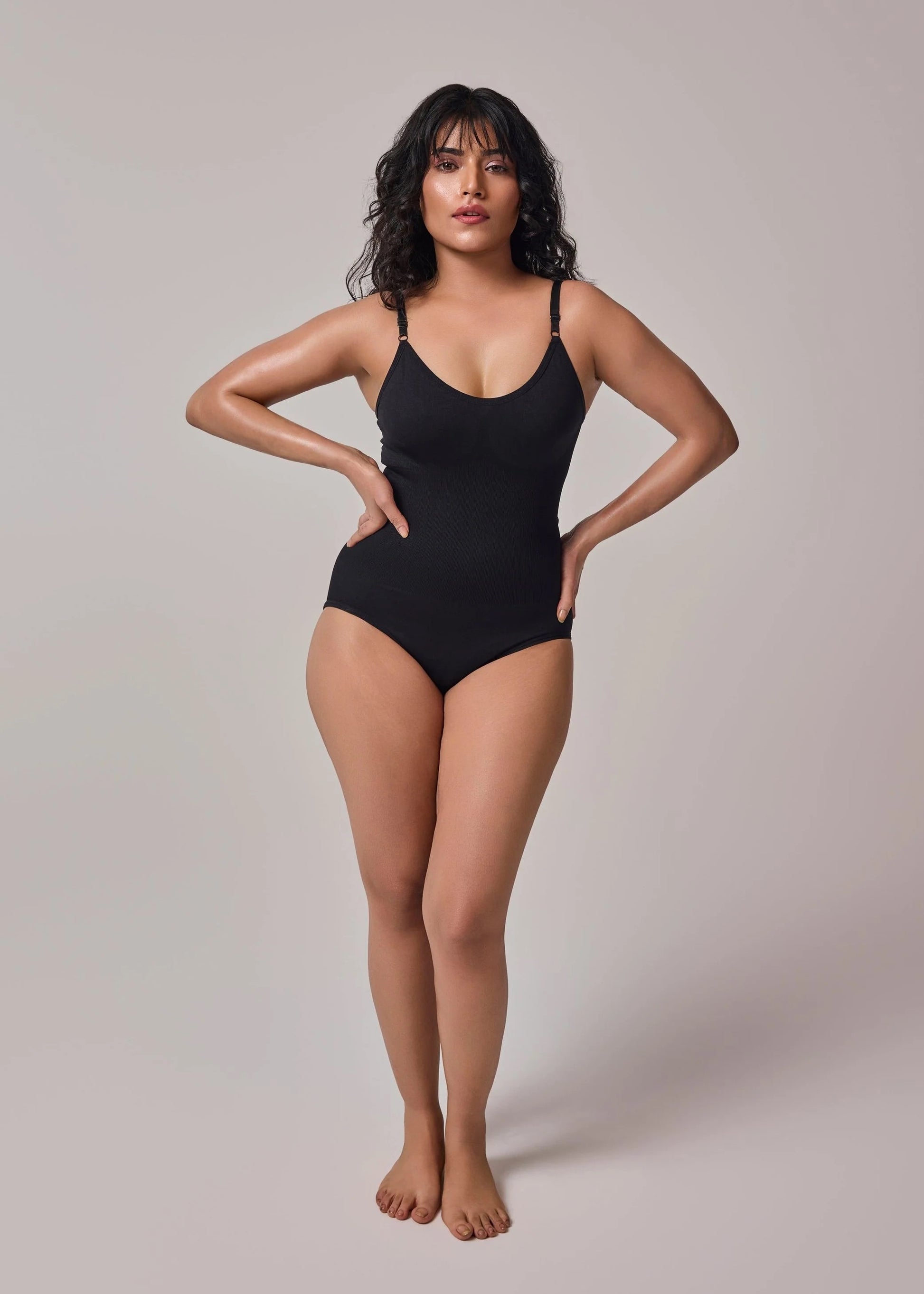 Model in black seamless tummy-control shapewear bodysuit – front view