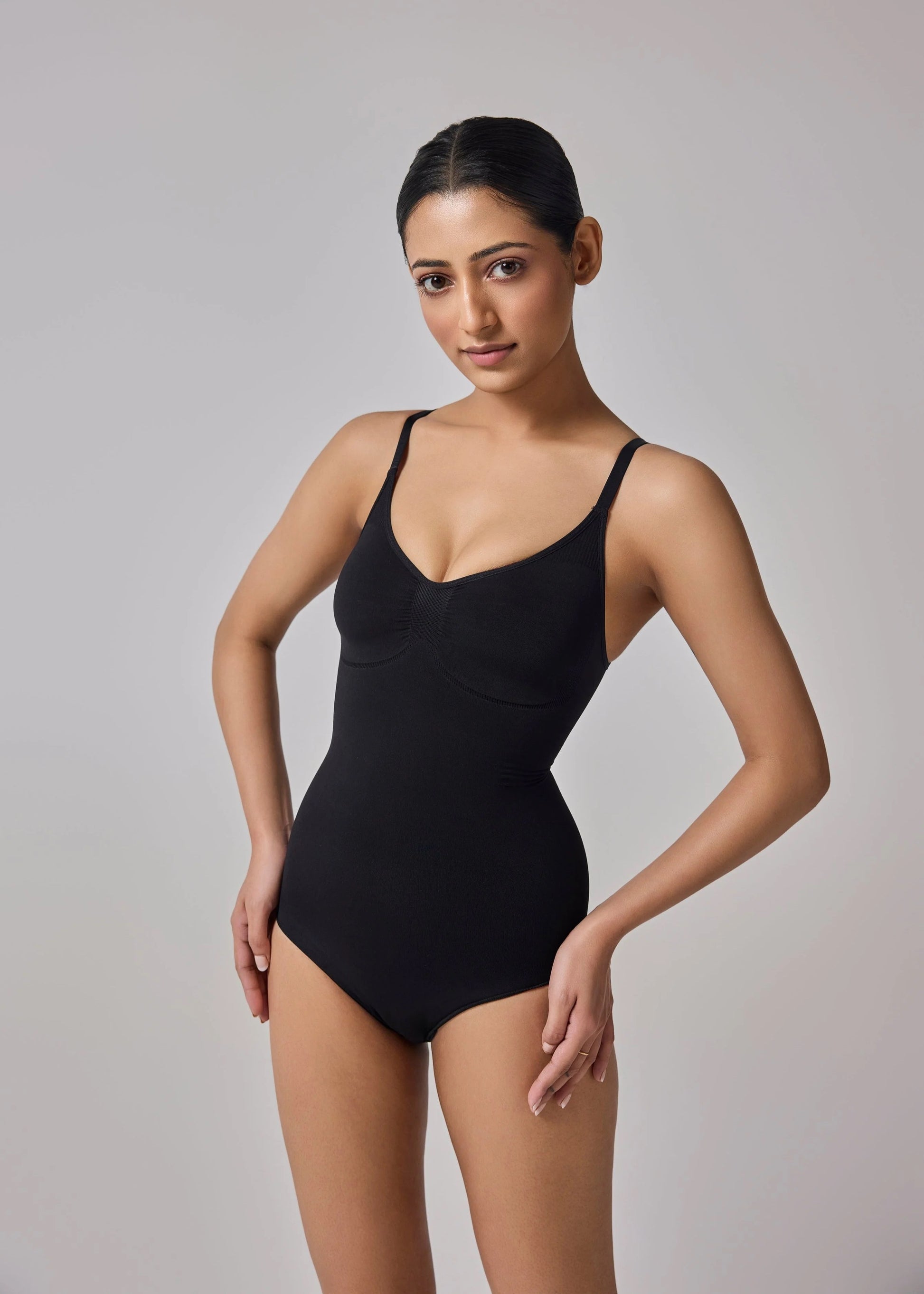 Model in black seamless tummy-control shapewear bodysuit – front view